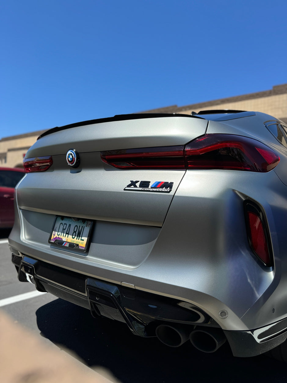 Matte silver BMW car with a clear blue sky in the background