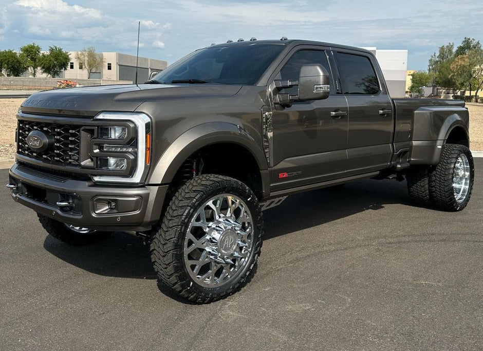 Gray pickup truck on a paved surface with a clear sky in the background