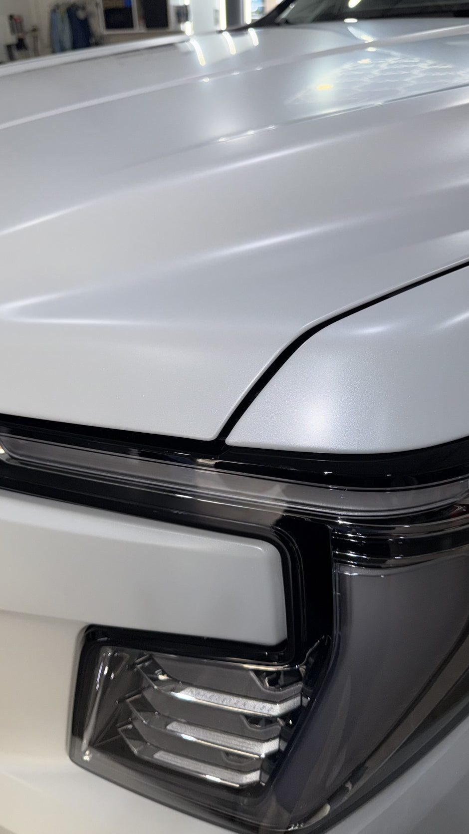 Close-up of a car headlight on a white vehicle