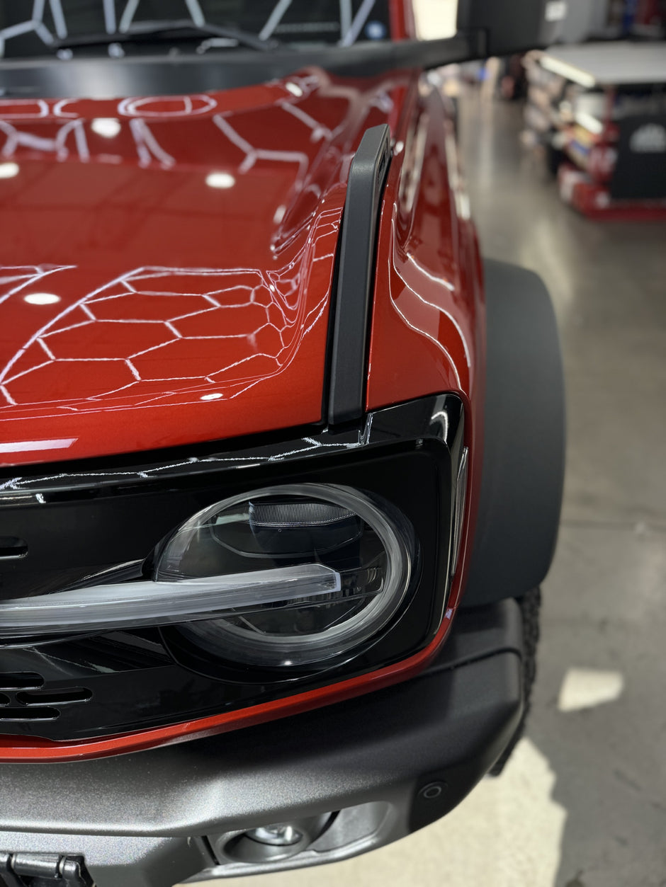 Close-up of a red bronco front bumper, grille, and hood