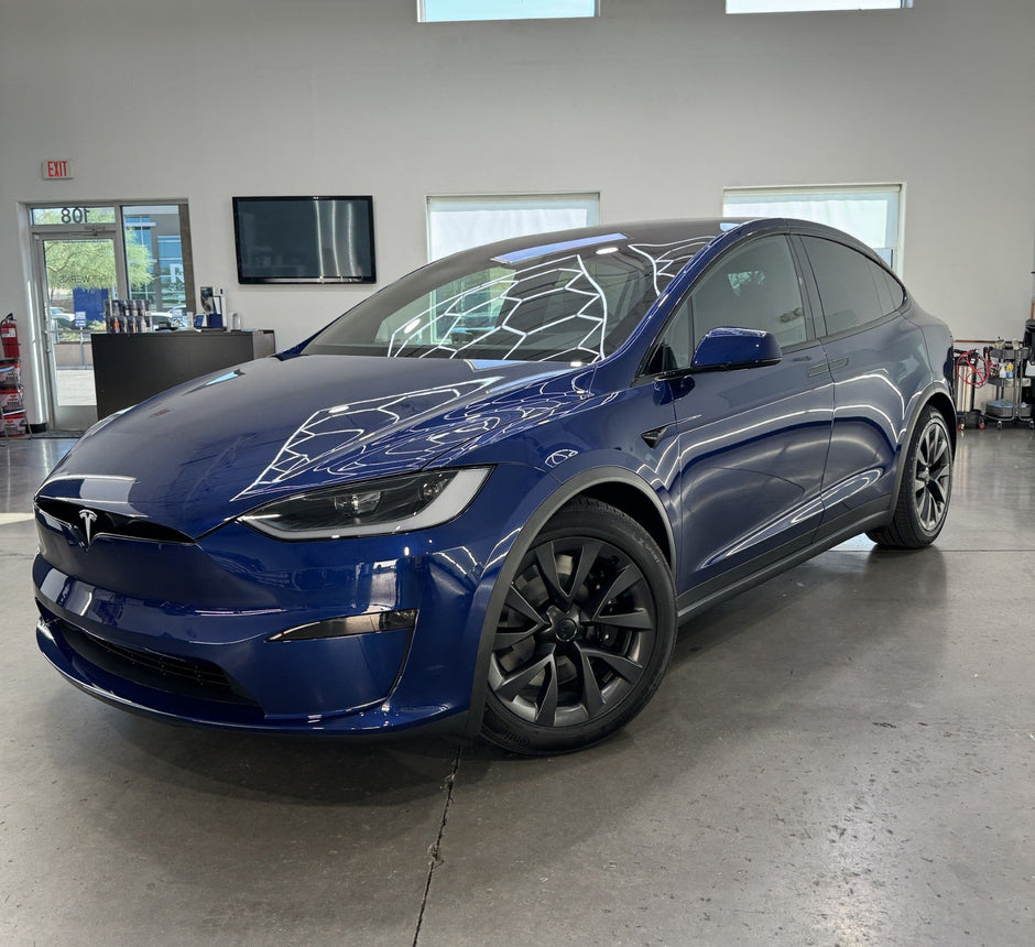 Blue Tesla Model X in a showroom setting