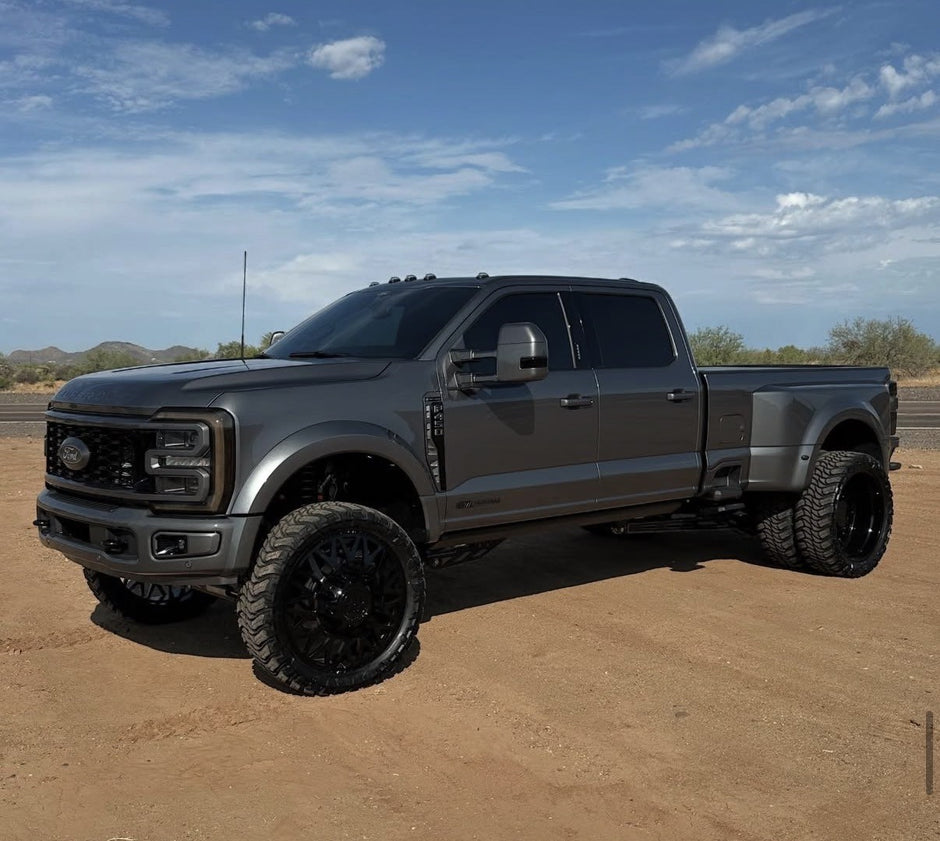 Gray pickup truck on a dirt road with a clear sky