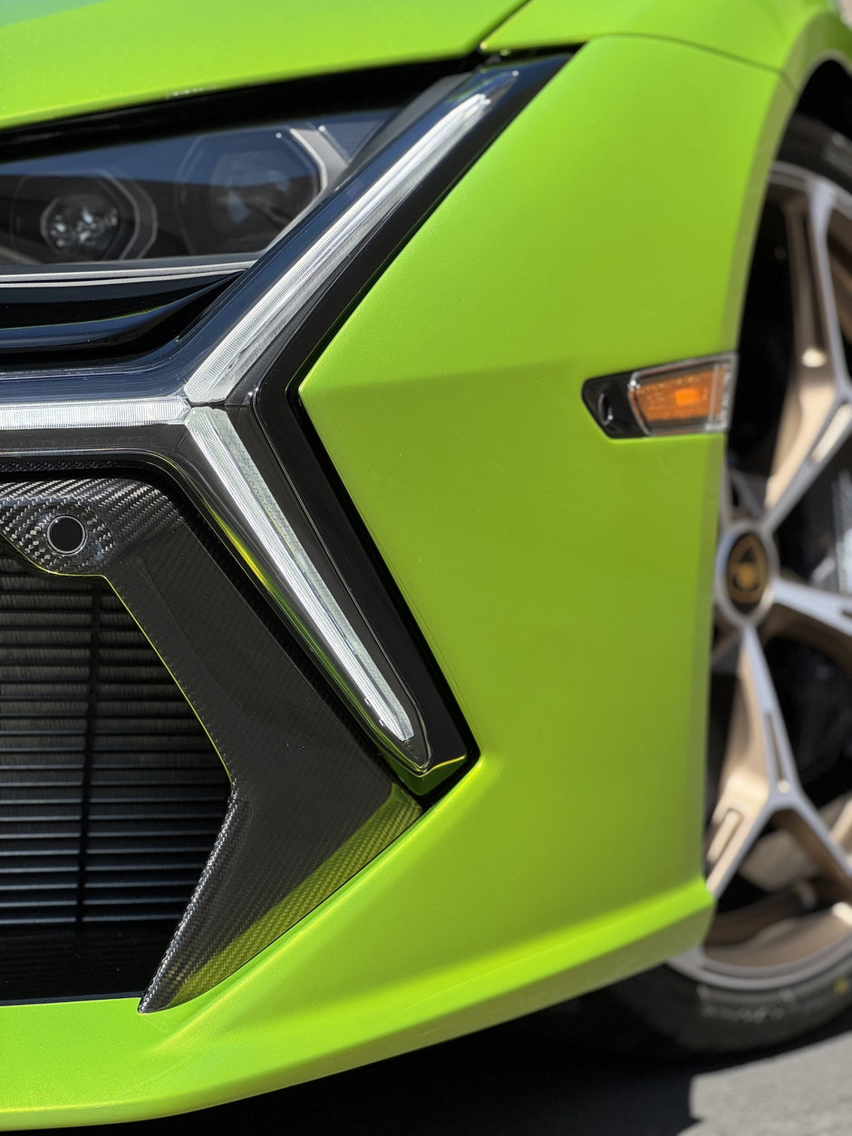 Close-up of a green Lamborghini front bumper and wheel.